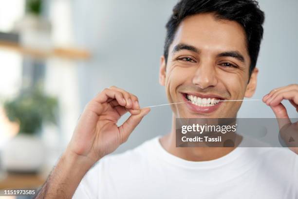 flossing für gesündere zähne - zahnseide stock-fotos und bilder