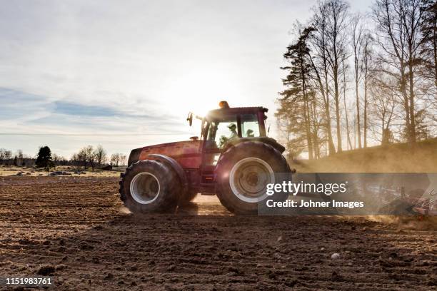 tractor plowing field - trekker stockfoto's en -beelden