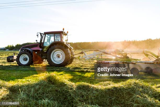 tractor with hay tedder on field - machine agricole photos et images de collection