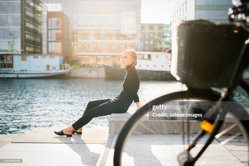 Woman sitting by river