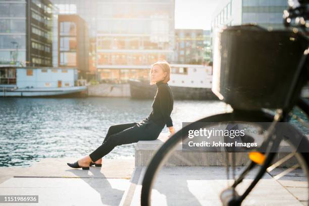 woman sitting by river - malmo stock pictures, royalty-free photos & images