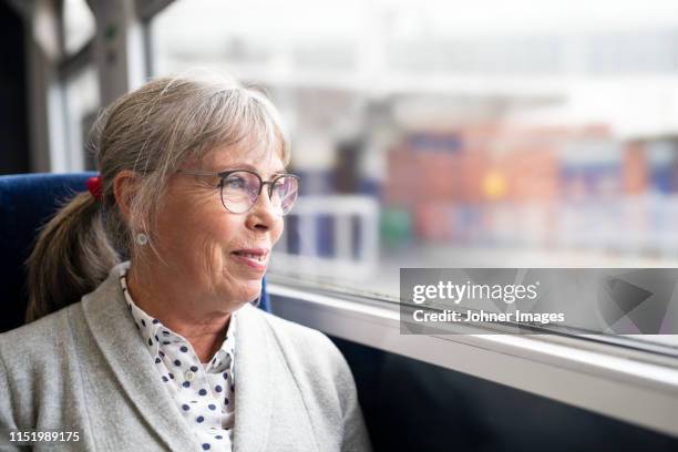 woman in bus looking through window - bus interior fotografías e imágenes de stock