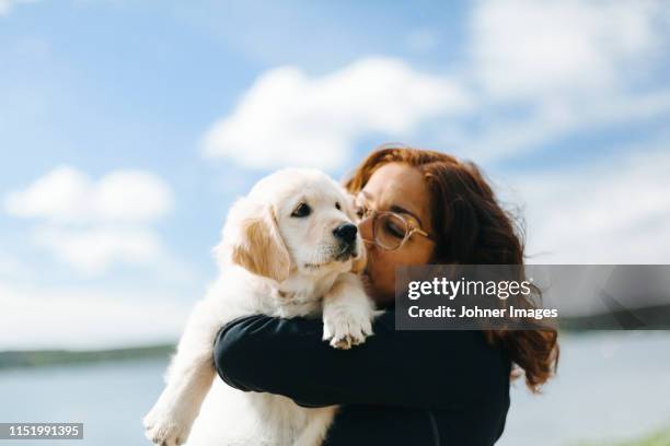 woman carry puppy - hondje stockfoto's en -beelden