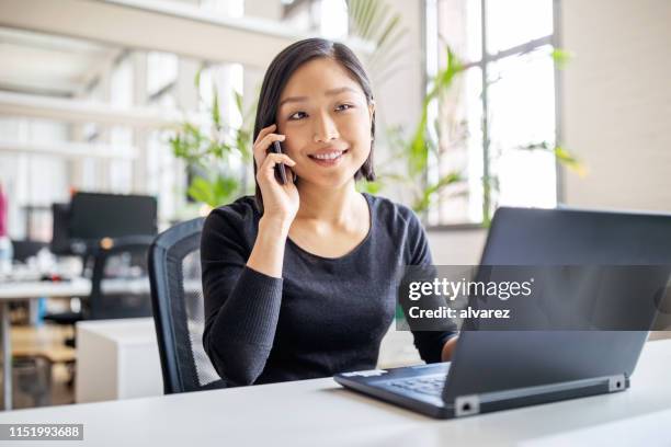 female professional working in modern office - businesswoman talking smartphone stock pictures, royalty-free photos & images