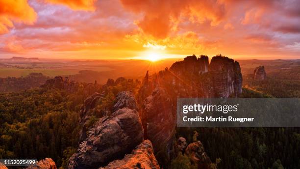 rocks and rock needles of the schrammsteine and falkenstein, at a dramatic sunset. - saxony stockfoto's en -beelden