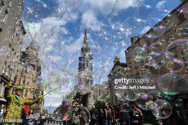 Street performer on the Royal Mile entertains members of the public with a mass of bubbles on May 27, 2019 in Edinburgh, Scotland.