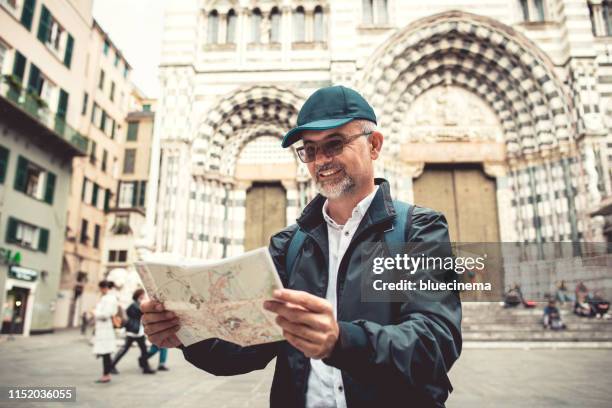 homme de touriste avec la carte au cattedrale san lorenzo - genoa italy photos et images de collection