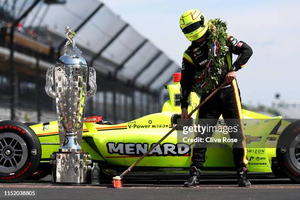 Simon Pagenaud of France, driver of the Team Penske Chevrolet sweeps the yard of bricks during the Winner's Portraits session after the 103rd running...