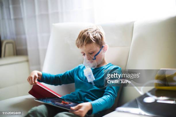 un niño usando un inhalador - nebulizador fotografías e imágenes de stock
