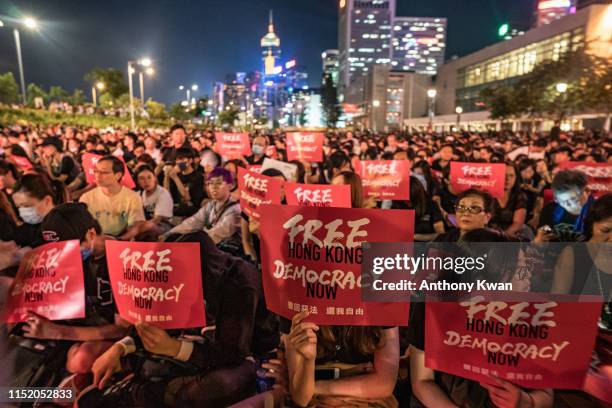 Protesters hold placards as they take part in a rally against the extradition bill ahead of 2019 G20 Osaka summit at Edinburgh Place in Central...