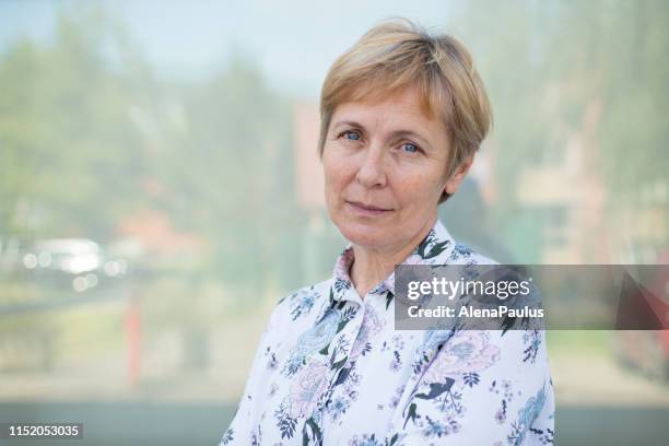 onafhankelijke senior vrouw met kort haar portret buitenshuis - portrait woman 50 serious stockfoto's en -beelden