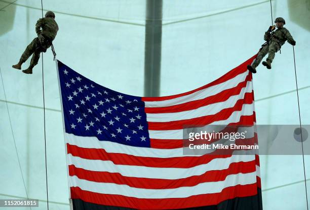 Members of the United States Special Operations command out of McDill AFB lower the flag onto the field during a game between the Tampa Bay Rays and...