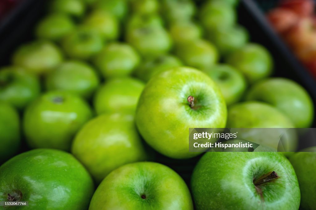Delicious green apples on retail display at supermarket