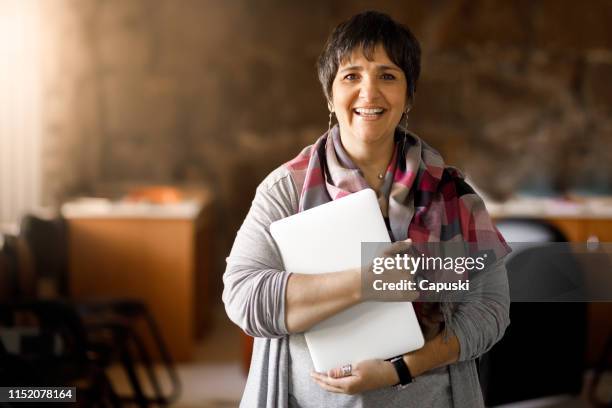 adult student holding laptop - teachers imagens e fotografias de stock