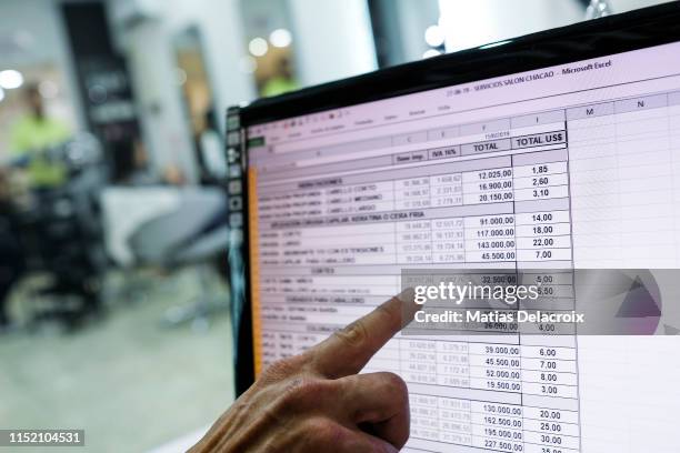 Man shows different hair cuts and hair styles prices from a spreadsheet on his computer on June 26, 2019 in Caracas, Venezuela. Everyday, more...