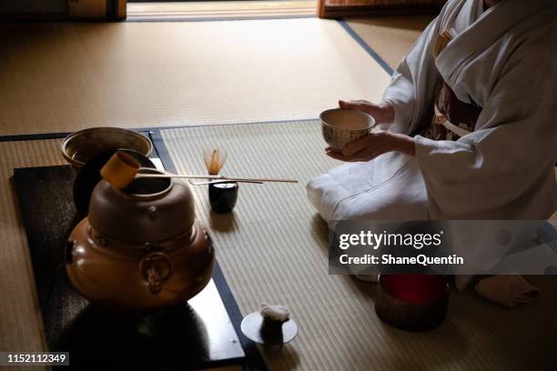 femme japonaise cradling bowl dans la cérémonie de thé - cérémonie du thé photos et images de collection