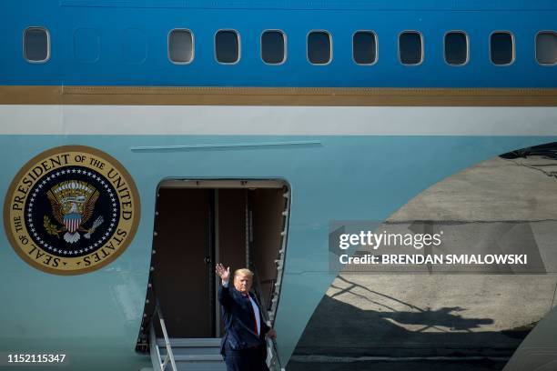 President Donald Trump waves after greeting troops as Air Force One is refueled at Elmendorf Air Force Base while traveling to Japan on June 26 in...