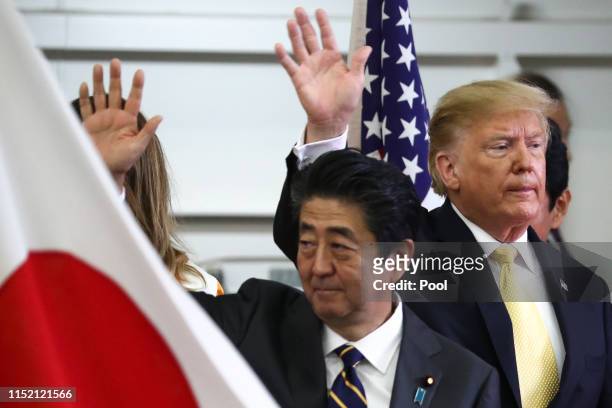 President Donald Trump and Japan's Prime Minister Shinzo Abe wave after delivering a speech to Japanese and U.S. Troops as they aboard Japan Maritime...