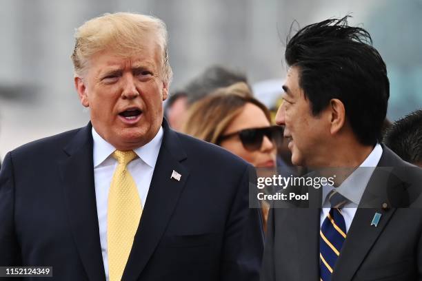 President Donald Trump talks with Japan's Prime Minister Shinzo Abe as he leaves the Japan's navy ship Kaga on May 28, 2019 in Yokosuka, Kanagawa,...