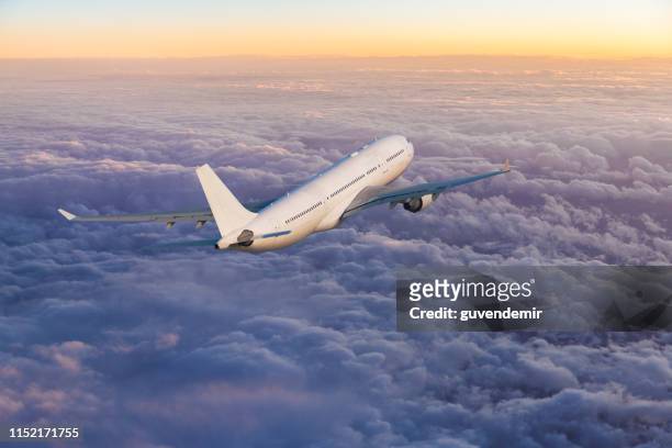passenger jet airplane flying above clouds at sunset - airplane take off stock pictures, royalty-free photos & images