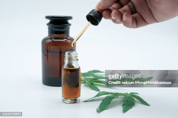hand holding bottle of cannabis oil in pipette isolated on white - cannabis oil fotografías e imágenes de stock