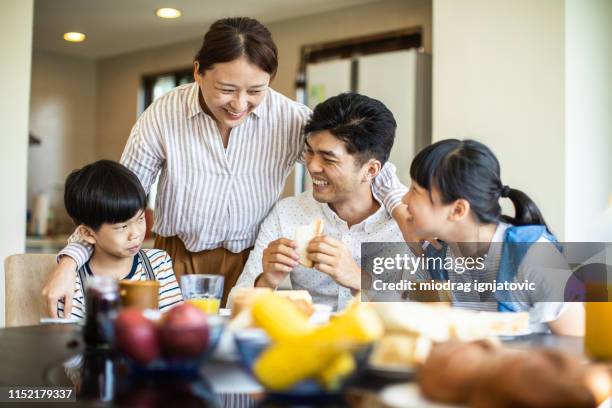 cheerful taiwanese family having breakfast at home - sandwich generation stock pictures, royalty-free photos & images