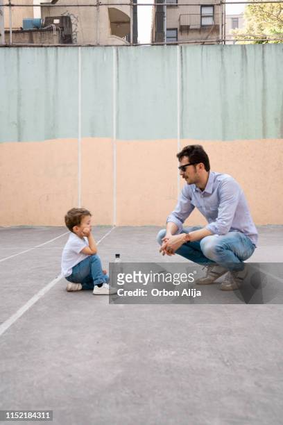 Father and son playing on tennis court