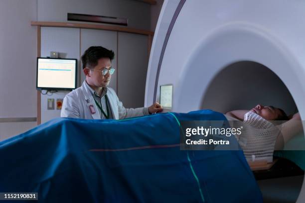 doctor preparando paciente para resonancia magnética - pet scan machine fotografías e imágenes de stock