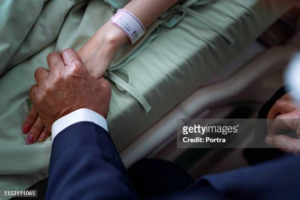 cropped image of father comforting sick daughter - hospital identification bracelet stock pictures, royalty-free photos & images