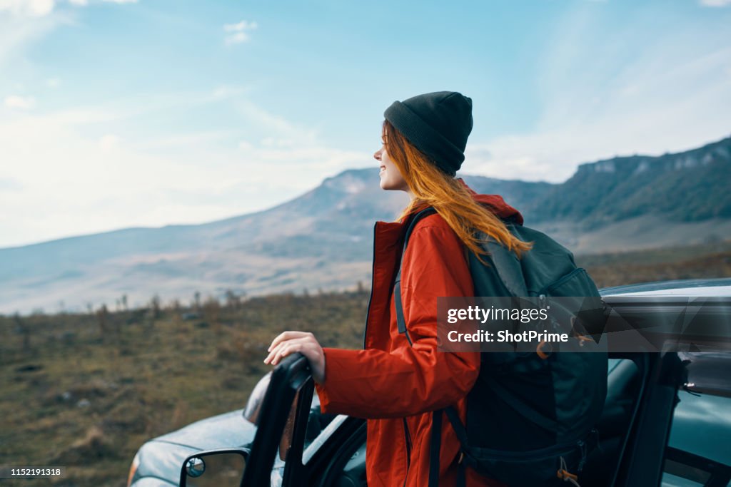 Woman tourist in the car looks at the mountains