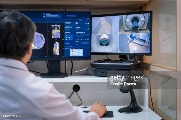 doctor werkende mri-scanner op de computer - radioloog stockfoto's en -beelden