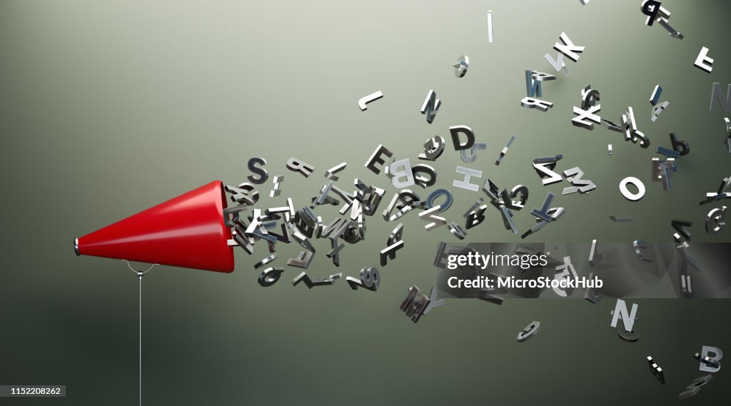Red Megaphone And Silver Alphabet Letters In Front Of Gray Wall