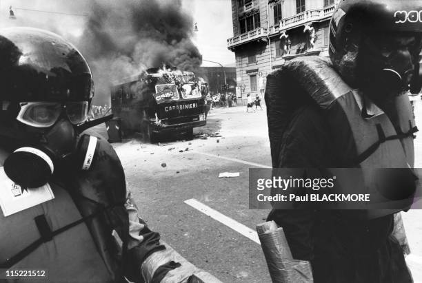 Members of Tutte Bianche walk away after setting an Italian police vehicle on fire during protests against the 27th Group of Eight Summit in July,...