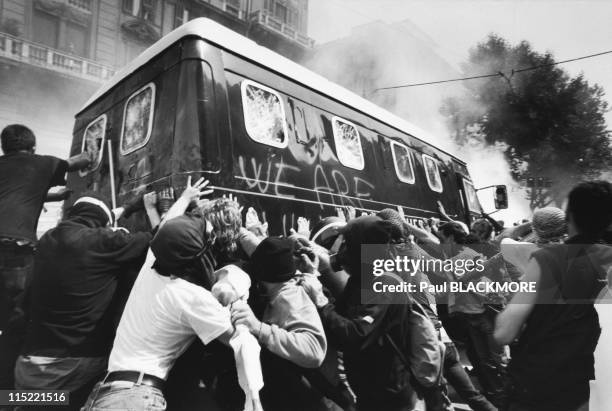 Protesters attack an Italian police vehicle during protests against the 27th Group of Eight Summit in July, 2001 in Genoa, Italy. Hundreds of...