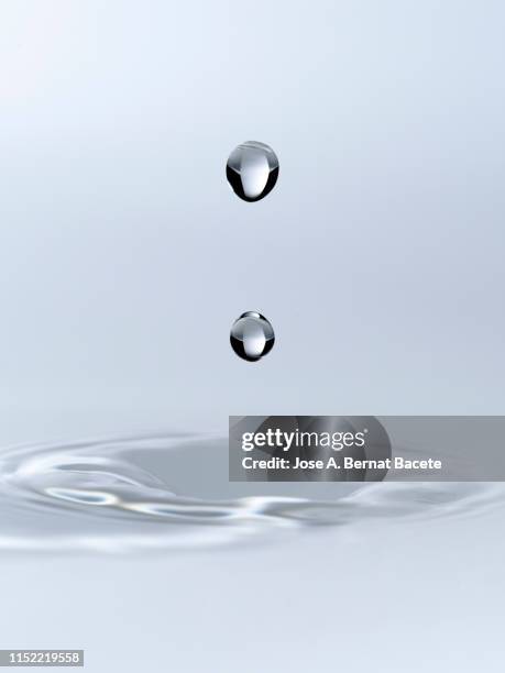 group of drops on line suspended in the air, falling down on a water surface that forms figures and abstract forms, on a white background. - onde sinusoïdale photos et images de collection