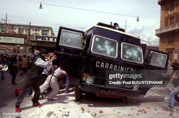 Members of Tutte Bianche attack a police vehicle during protests against the 27th Group of Eight Summit on July 20, 2001 in Genoa, Italy. Hundreds of...