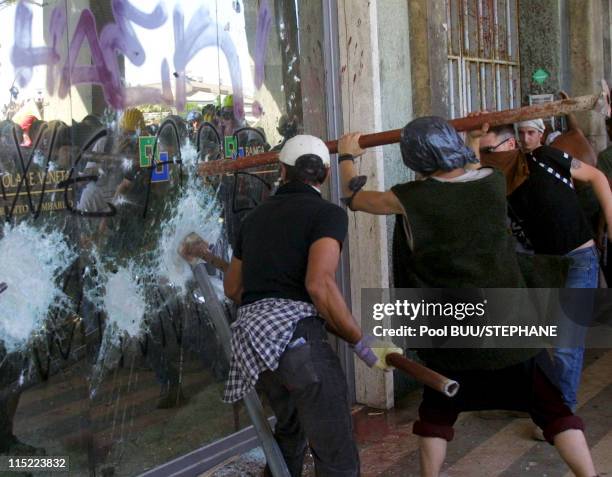 Demonstrators smash a window during protests against the 27th Group of Eight Summit on July 21, 2001 in Genoa, Italy. Hundreds of thousands of...