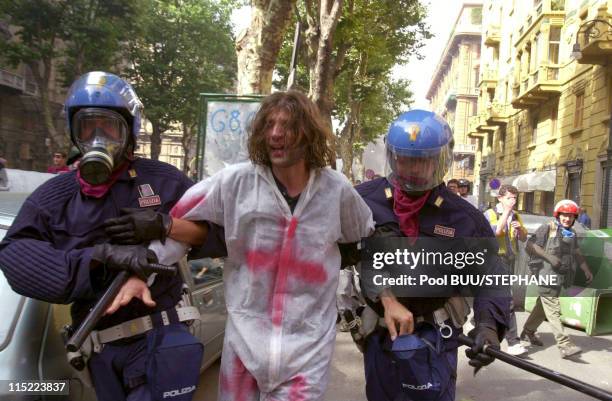 Member of Tutte Bianche is led away by police during protests against the 27th Group of Eight Summit on July 20, 2001 in Genoa, Italy. Hundreds of...