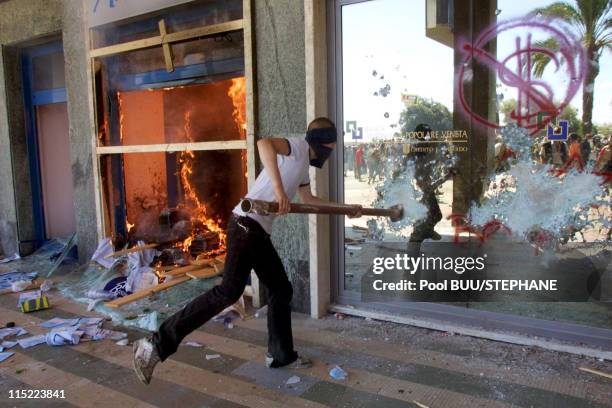 Protester smashes a window during protests against the 27th Group of Eight Summit on July 21, 2001 in Genoa, Italy. Hundreds of thousands of...