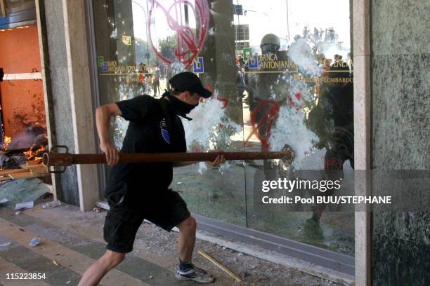 Demonstrator smashes a window during protests against the 27th Group of Eight Summit on July 21, 2001 in Genoa, Italy. Hundreds of thousands of...