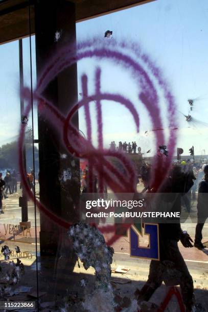 Demonstrators graffiti a window during protests against the 27th Group of Eight Summit on July 21, 2001 in Genoa, Italy. Hundreds of thousands of...