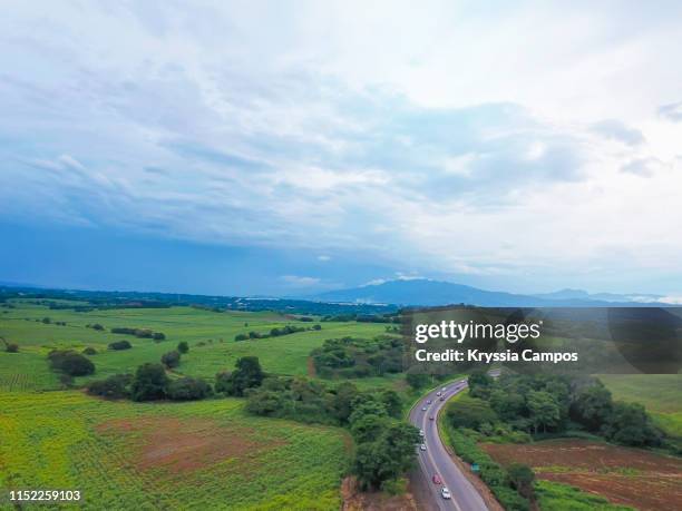 rainy sky above fields and road - grecia stock-fotos und bilder