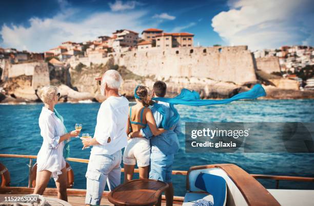 senior couple on a sailing cruise looking at coastline. - family wealth stock pictures, royalty-free photos & images