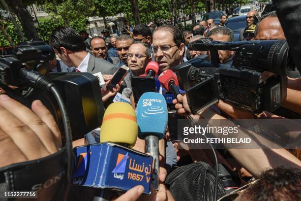 Tunisian Prime minister Youssef Chahed speaks with journalists outside the Interior Ministry headquarters near the scene of a suicide attack on...