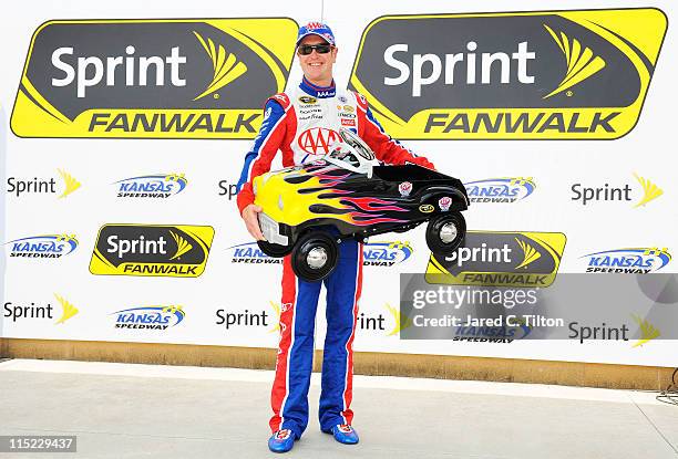 Kurt Busch, driver of the AAA Dodge, poses after winning the pole award in qualifying for the NASCAR Sprint Cup Series STP 400 at Kansas Speedway on...