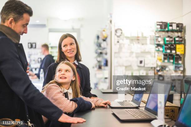 family discussing while standing in computer store - computer store photos et images de collection