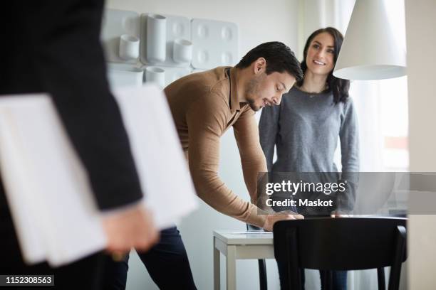 woman looking at real estate agent while man signing documents at new home - renting stock pictures, royalty-free photos & images