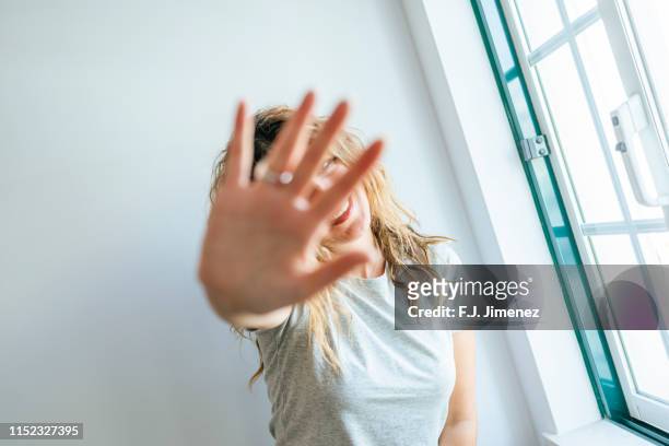 portrait of woman covering her face with her hand - f stop stock pictures, royalty-free photos & images