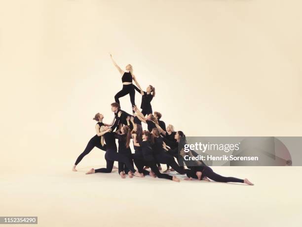 group of young people forming a pyramid - akrobatische aktivität stock-fotos und bilder