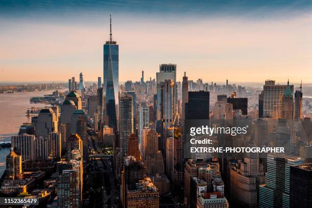 the majesty of manhattan island taken from a helicopter above the downtown area at a golden hour - new york state stock pictures, royalty-free photos & images